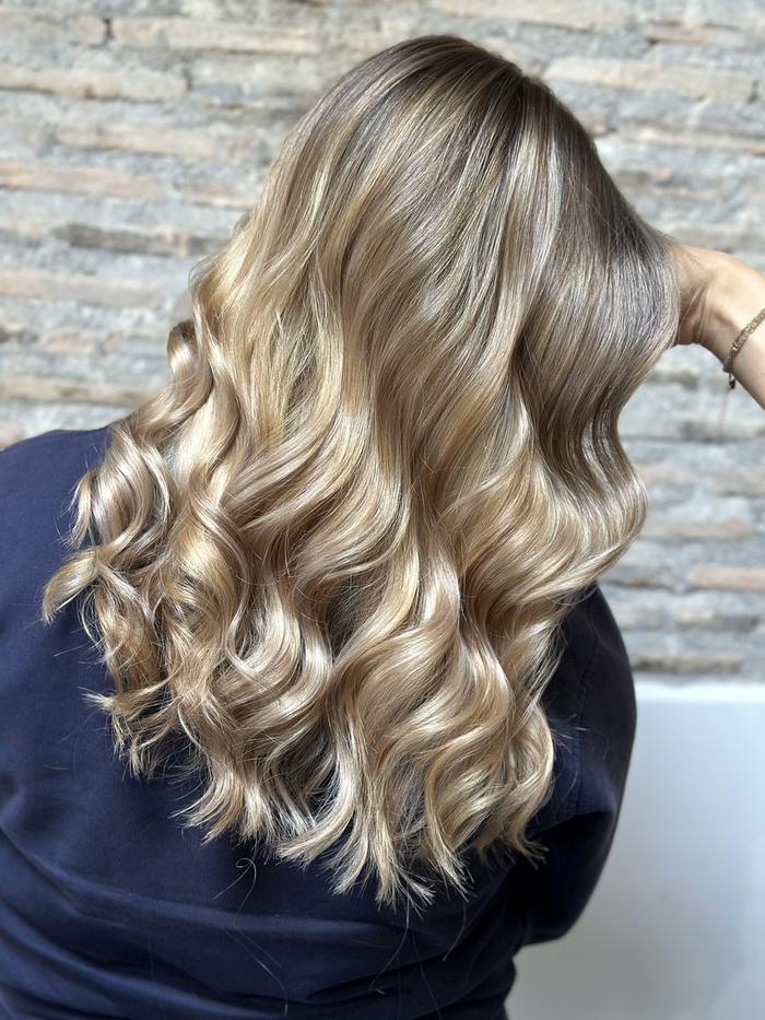 Balayage-ombré dimension, après : blond dimensionnel bouclé, racine fondue