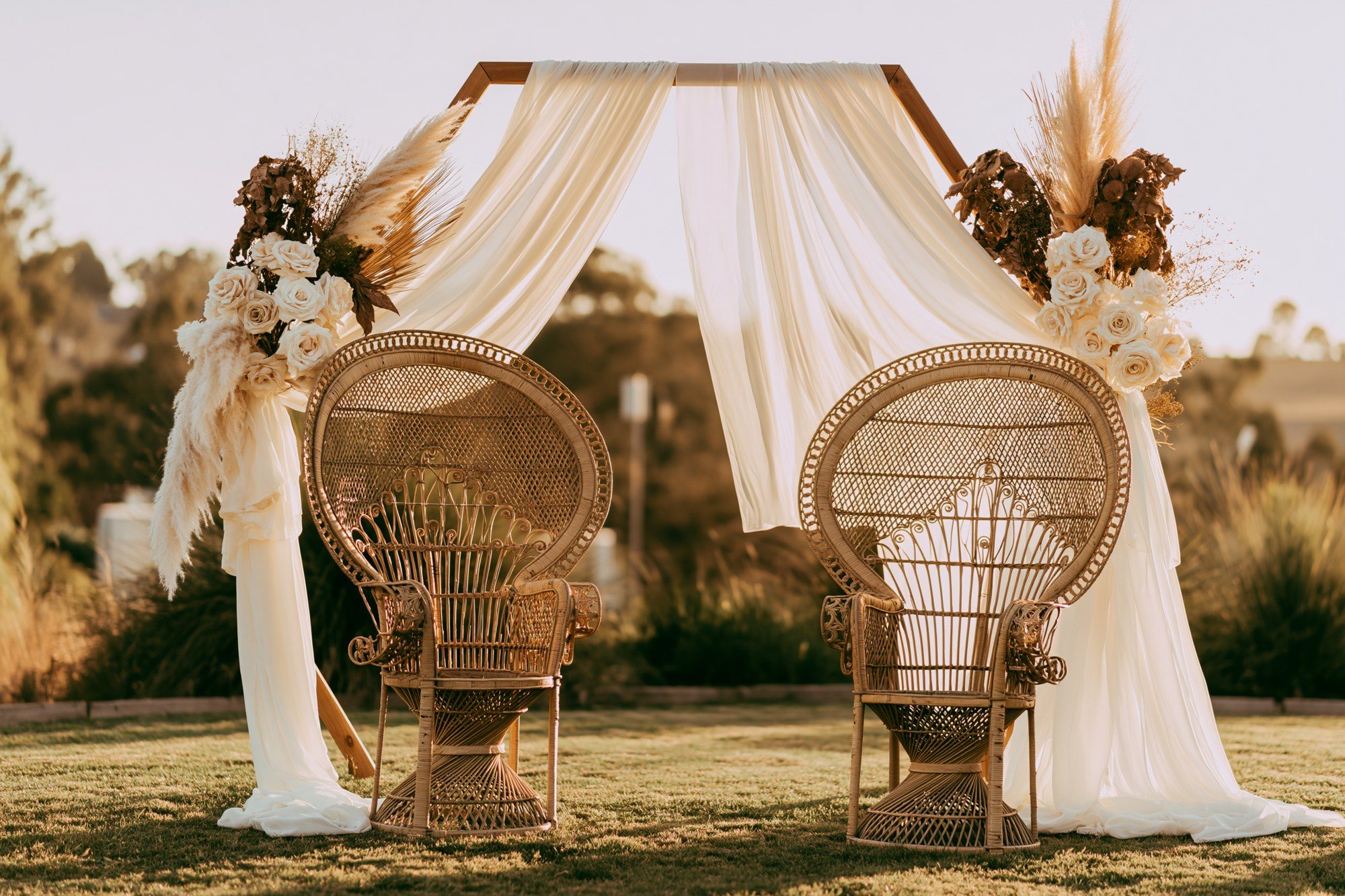 Décor de cérémonie — fauteuils en rotin et arche fleurie